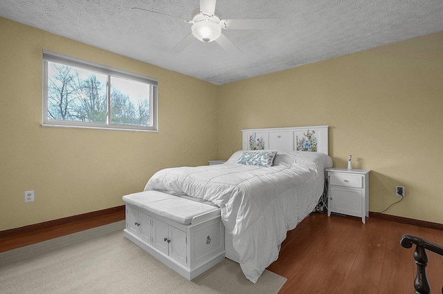 bedroom featuring hardwood / wood-style floors, a textured ceiling, and ceiling fan