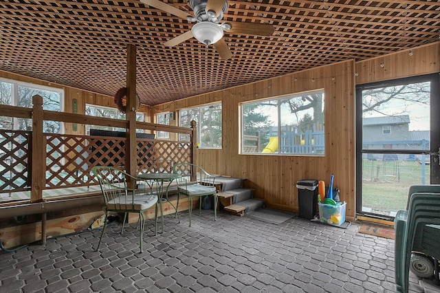 unfurnished sunroom featuring ceiling fan