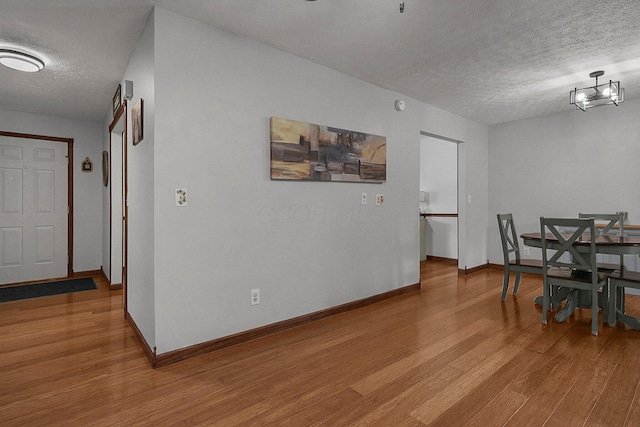 dining area with a textured ceiling and light hardwood / wood-style floors