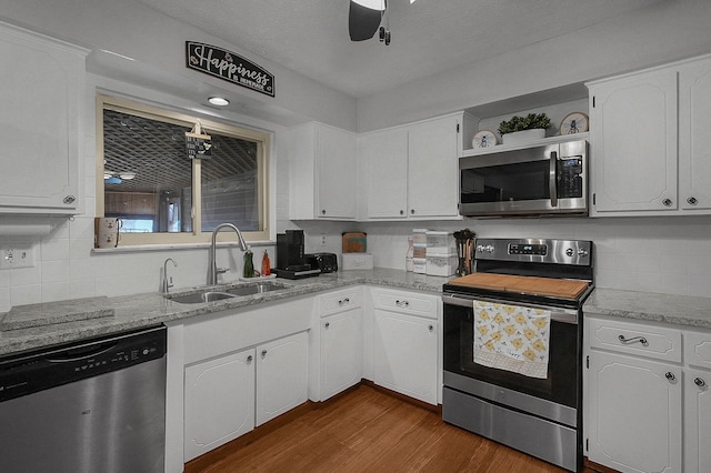 kitchen featuring sink, appliances with stainless steel finishes, dark hardwood / wood-style floors, ceiling fan, and white cabinets