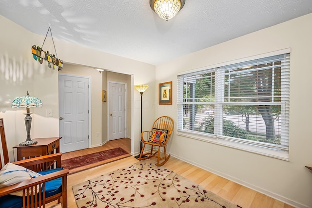 sitting room with a textured ceiling and hardwood / wood-style flooring