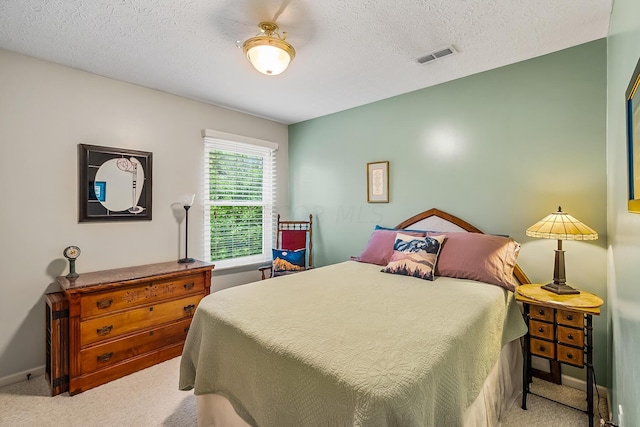 bedroom with a textured ceiling and light carpet