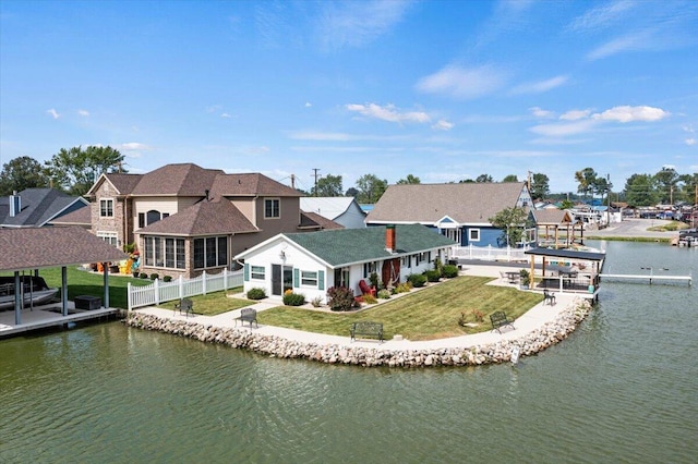 back of property featuring a water view and a lawn