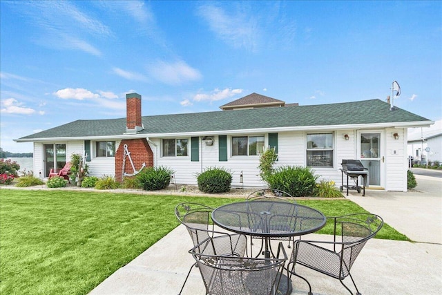 back of property featuring a lawn and a patio area