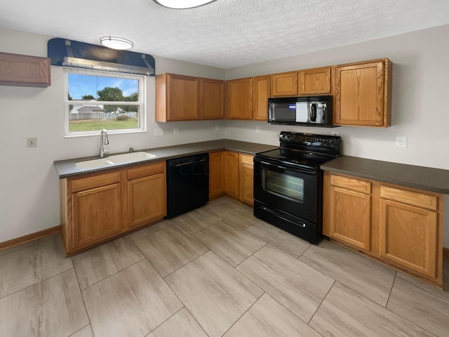 kitchen with sink, black appliances, and a textured ceiling