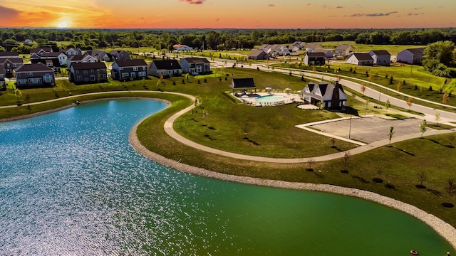 aerial view at dusk featuring a water view