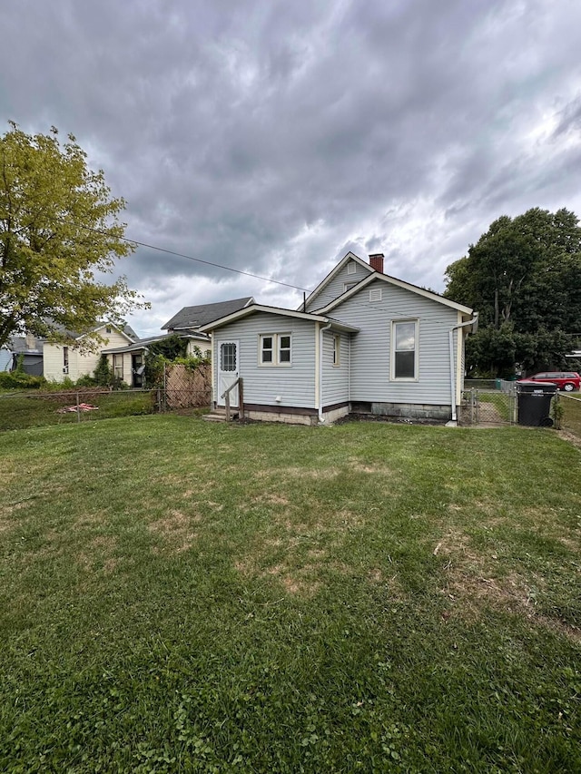 rear view of property with a lawn