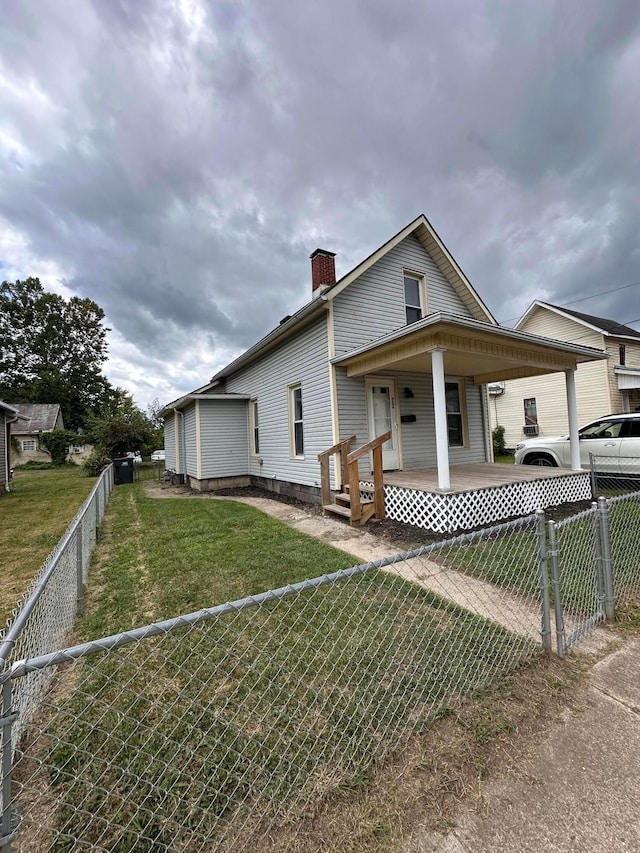 view of side of property featuring a porch and a yard