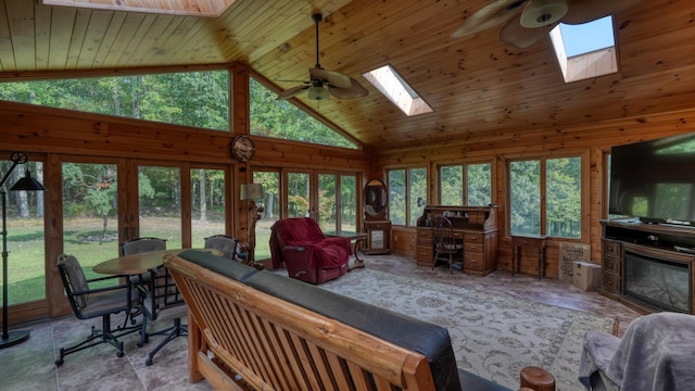 living room with a wealth of natural light, high vaulted ceiling, and a skylight