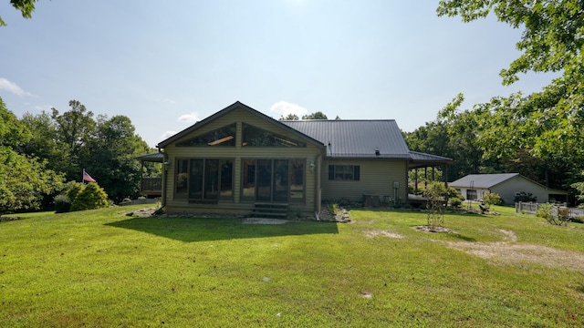 rear view of house with a sunroom and a yard