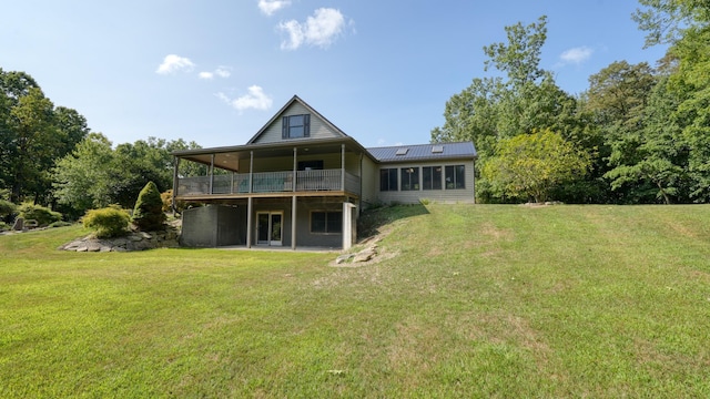 back of house with a lawn, a sunroom, and a deck