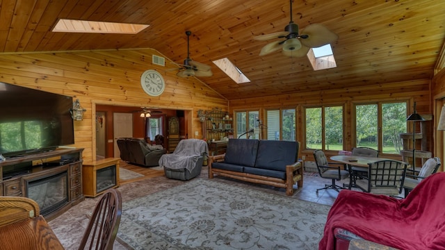 living room with a skylight, wood walls, high vaulted ceiling, and wooden ceiling