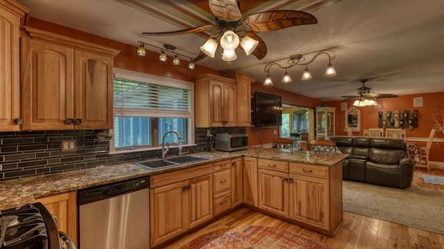 kitchen featuring sink, decorative backsplash, light wood-type flooring, appliances with stainless steel finishes, and kitchen peninsula