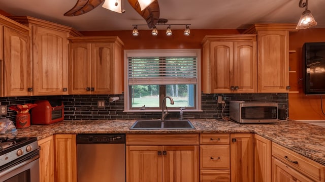 kitchen with decorative backsplash, sink, pendant lighting, and appliances with stainless steel finishes