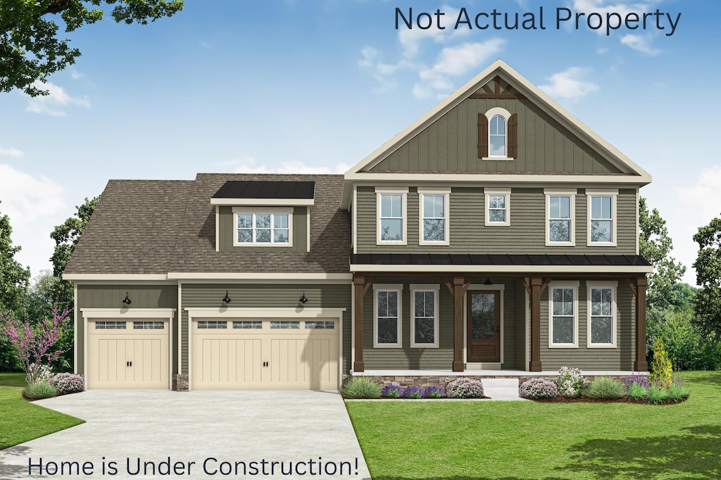 craftsman-style house featuring covered porch, board and batten siding, a garage, driveway, and a front lawn