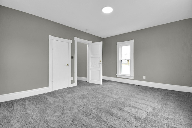 carpeted empty room featuring baseboards