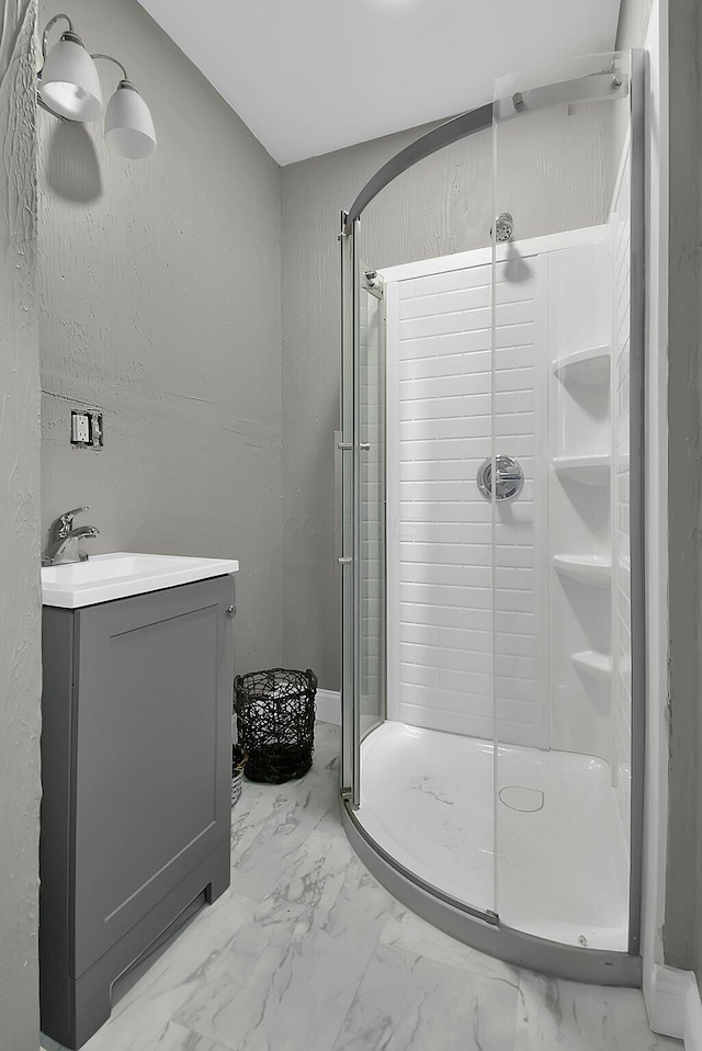 bathroom with vanity, a stall shower, and marble finish floor