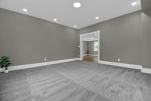 spare room with recessed lighting, carpet, and baseboards