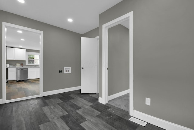 spare room with visible vents, baseboards, and dark wood-style flooring