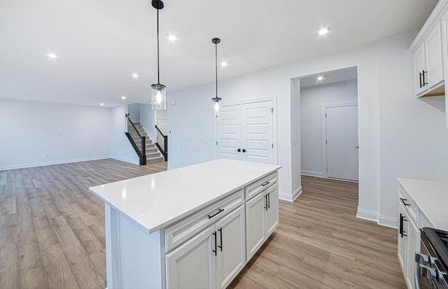 kitchen featuring white cabinets, a center island, and light hardwood / wood-style flooring