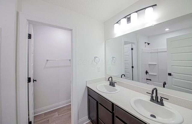 bathroom with bathtub / shower combination, vanity, and hardwood / wood-style flooring