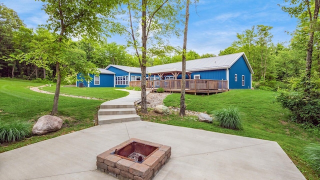 view of home's community featuring a yard, a fire pit, and a wooden deck