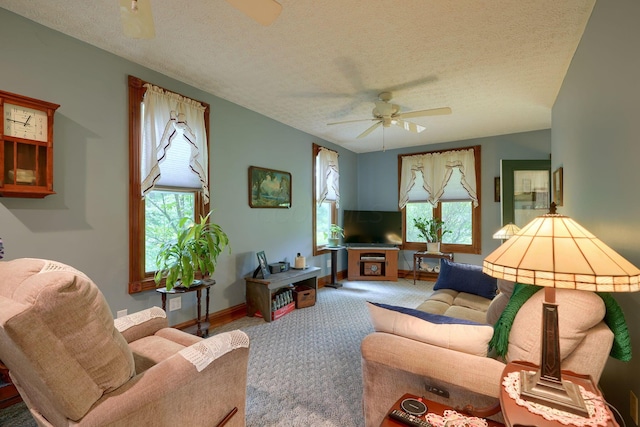 carpeted living room featuring ceiling fan, plenty of natural light, and a textured ceiling