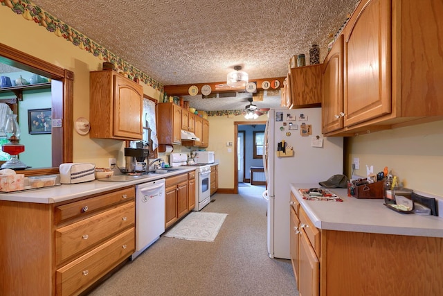 kitchen with white appliances, sink, ceiling fan, a textured ceiling, and light colored carpet