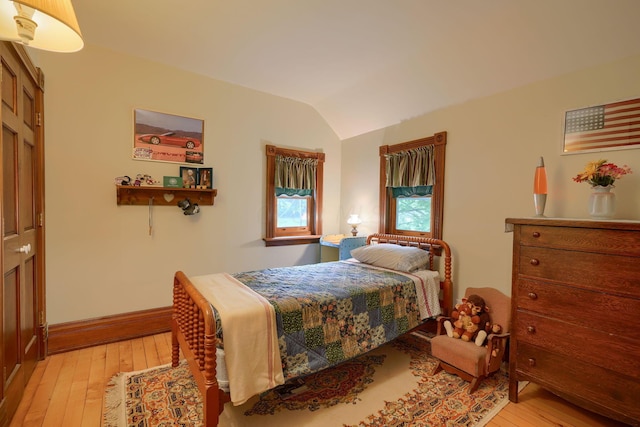 bedroom with light hardwood / wood-style floors and lofted ceiling