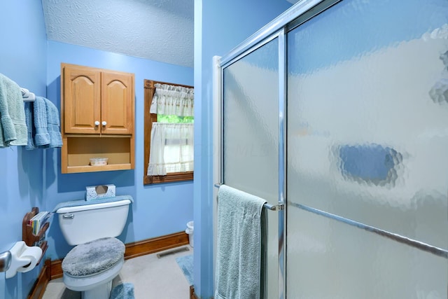 bathroom featuring toilet, a textured ceiling, and walk in shower