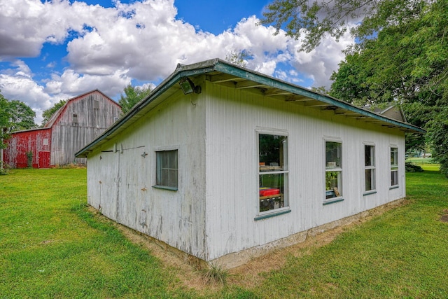 view of side of home with a lawn and an outdoor structure