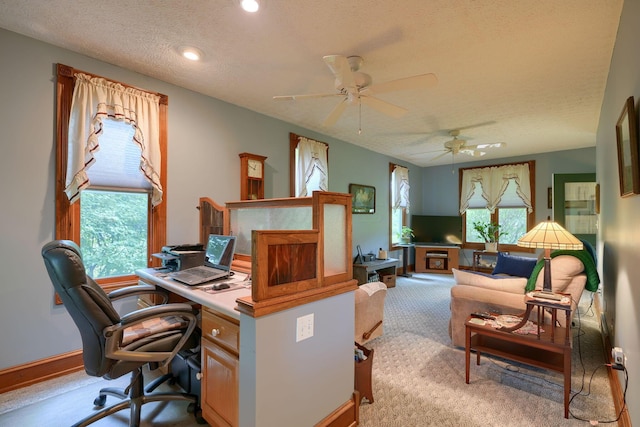 office area featuring a textured ceiling, light colored carpet, and ceiling fan