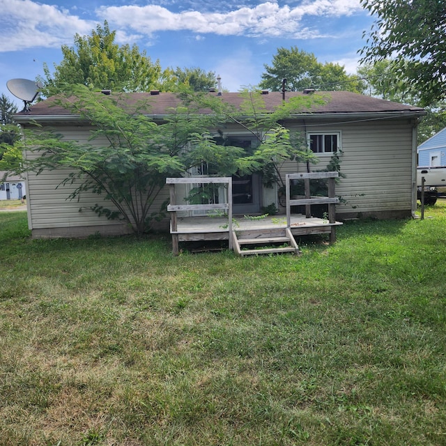 back of house featuring a lawn and a deck