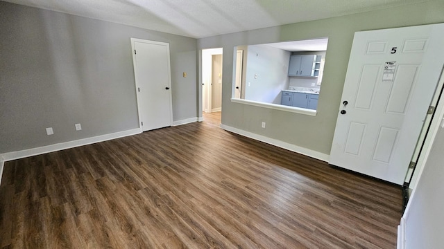 interior space featuring a textured ceiling and dark hardwood / wood-style floors