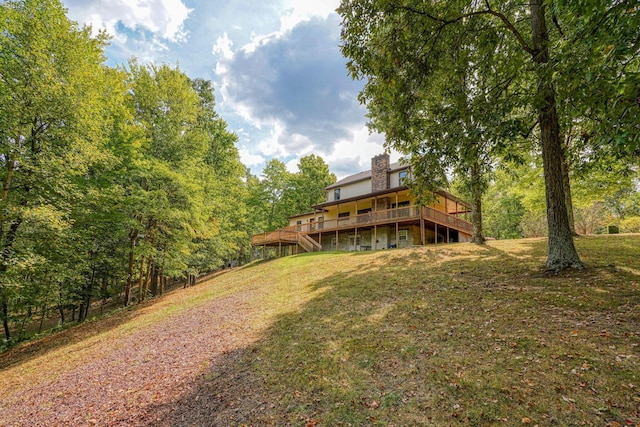 rear view of house with a lawn and a deck