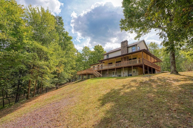 back of property featuring a lawn and a wooden deck