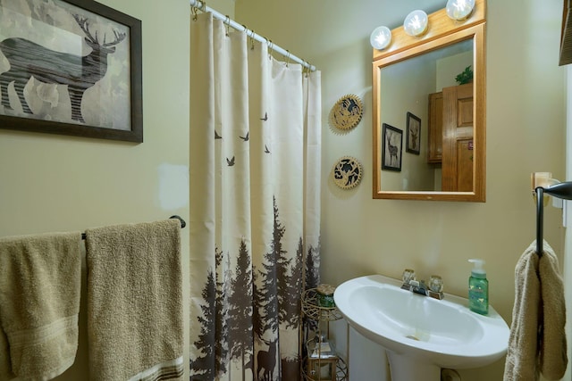 bathroom with a shower with shower curtain and sink