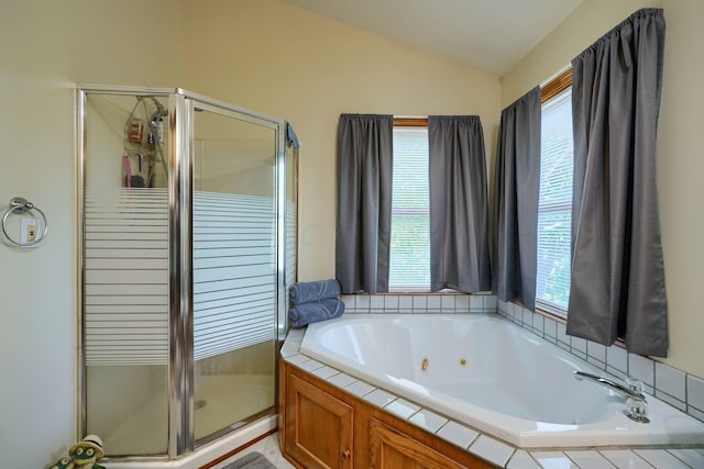 bathroom with vaulted ceiling, plenty of natural light, and independent shower and bath