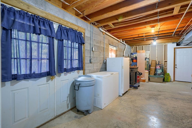 basement featuring white fridge and fridge