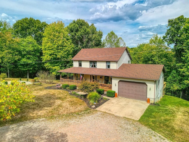 view of front of property with covered porch, a front yard, and a garage