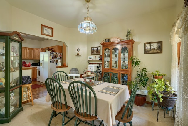 dining area with light hardwood / wood-style floors and an inviting chandelier