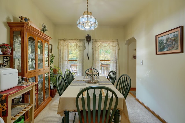 carpeted dining space featuring a chandelier