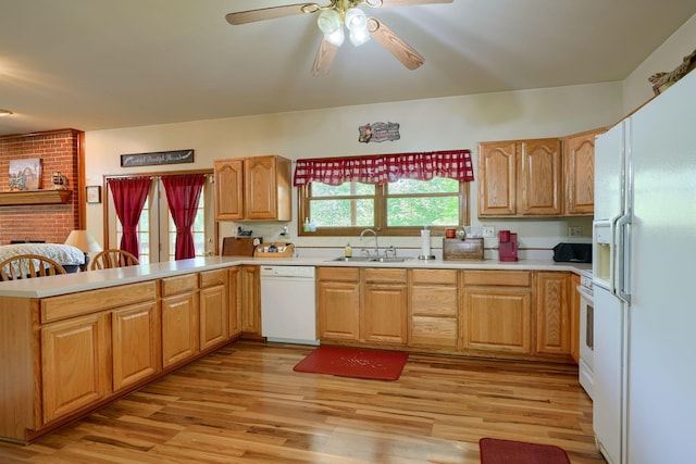 kitchen featuring kitchen peninsula, light wood-type flooring, white appliances, ceiling fan, and sink