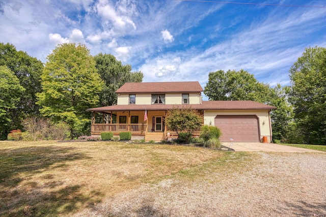 farmhouse featuring covered porch, a front yard, and a garage