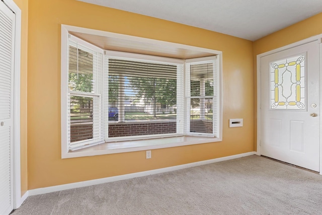 view of carpeted foyer entrance