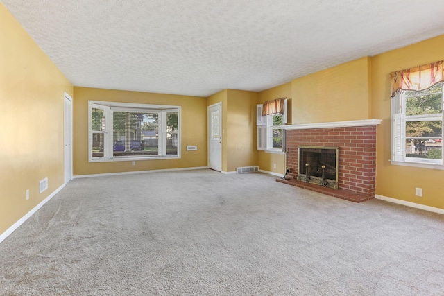 unfurnished living room featuring a textured ceiling, light carpet, and a brick fireplace