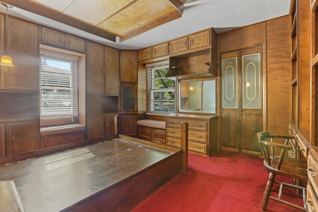 office with dark colored carpet and wooden walls