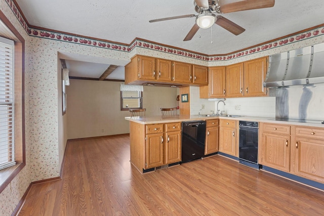 kitchen featuring black appliances, sink, light hardwood / wood-style flooring, a textured ceiling, and kitchen peninsula