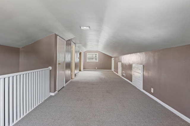 bonus room with light carpet and vaulted ceiling