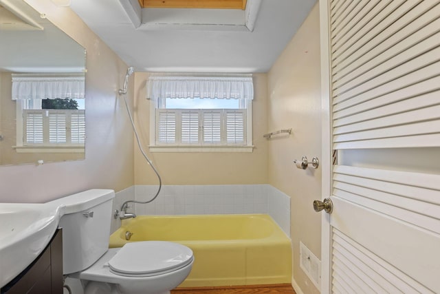 bathroom with a bathing tub, vanity, and toilet